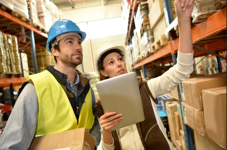 Addetti alla logistica Momoka con caschi e vesti da lavoro impegnati in un controllo della merce