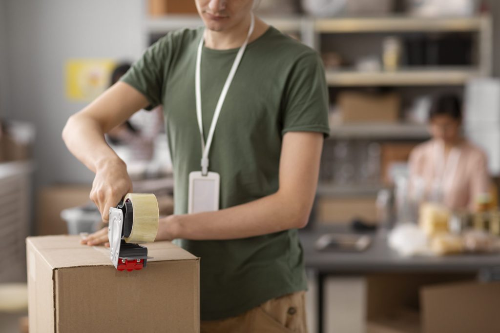 Dipendente che chiude con cura la scatola della spedizione