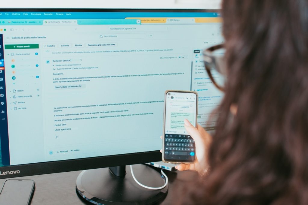 Impiegata intenta a rispondere a mail e messaggi whatsapp dei clienti di Momokacorp