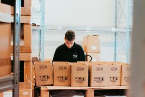 Operatore logistico Momoka specializzato nella preparazione e nel confezionamento di ordini e-commerce pronti per la spedizione.